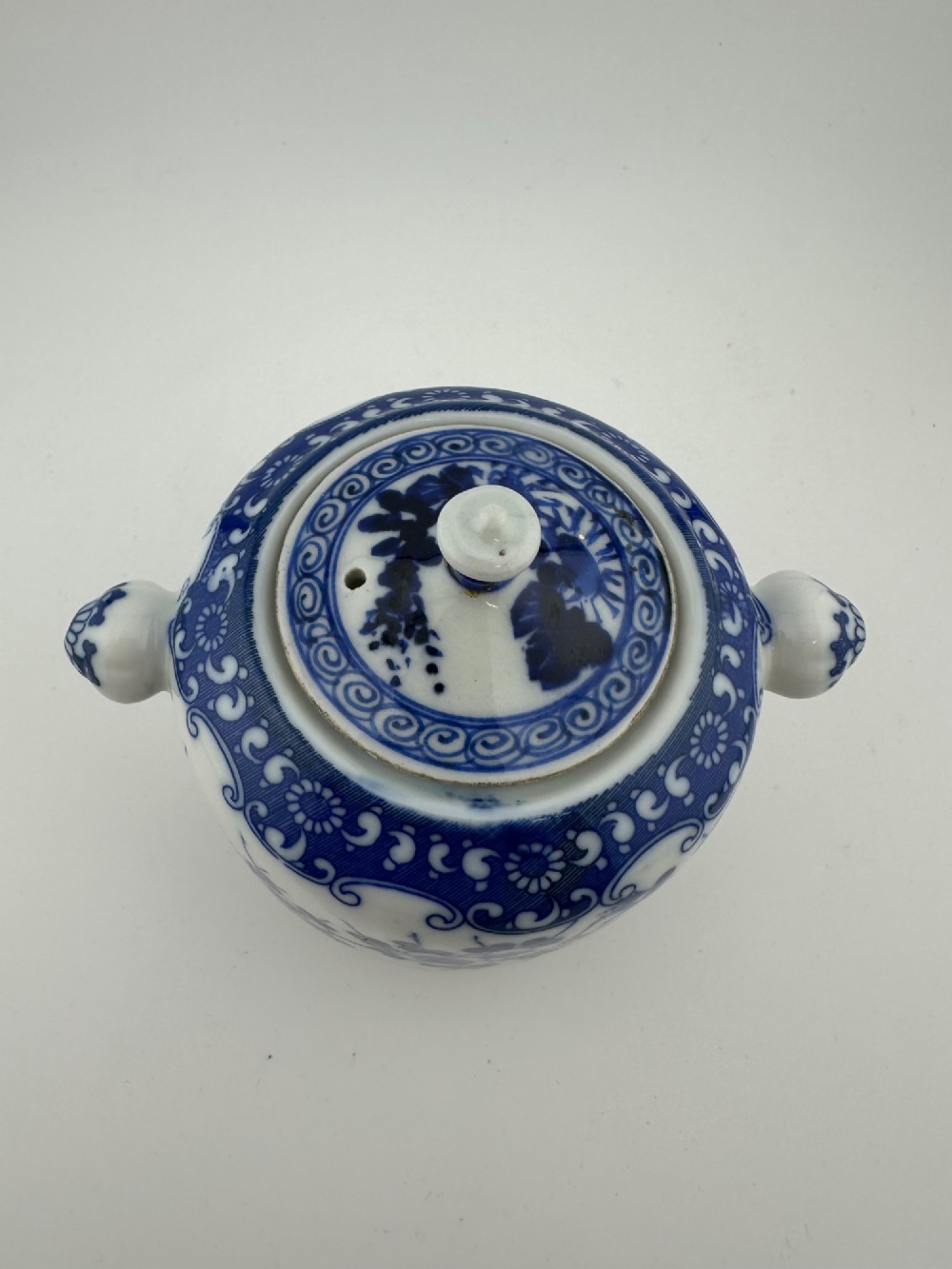 A Japanese Meiji period blue and white porcelain incense burner decorated with hand-painted prunus branches, featuring a fitted lid and side lugs. View III