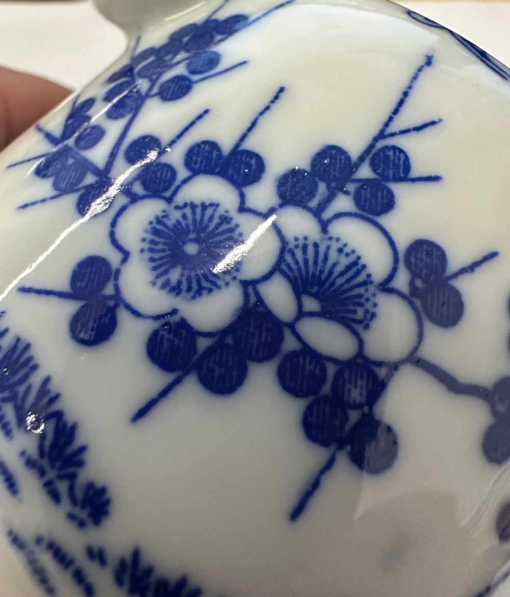 A Japanese Meiji period blue and white porcelain incense burner decorated with hand-painted prunus branches, featuring a fitted lid and side lugs. View X