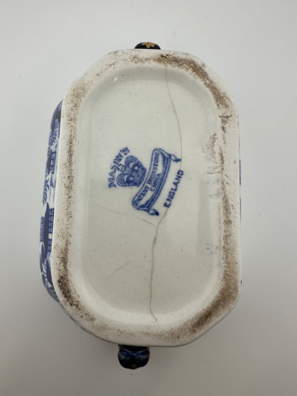 An antique oval ironstone jardiniere featuring blue and white transfer-printed Chinoiserie landscape decoration and small side handles with gilded detailing. View VI