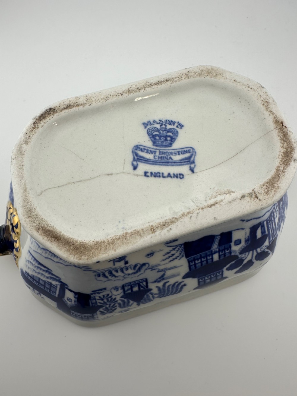 An antique oval ironstone jardiniere featuring blue and white transfer-printed Chinoiserie landscape decoration and small side handles with gilded detailing. View VIII