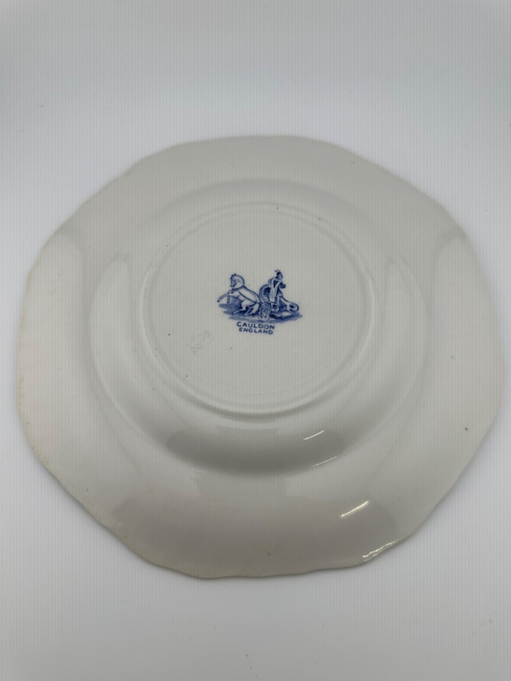 An octagonal-edged blue and white transferware plate featuring a central classical chariot scene surrounded by an ornate feather-patterned border. View II
