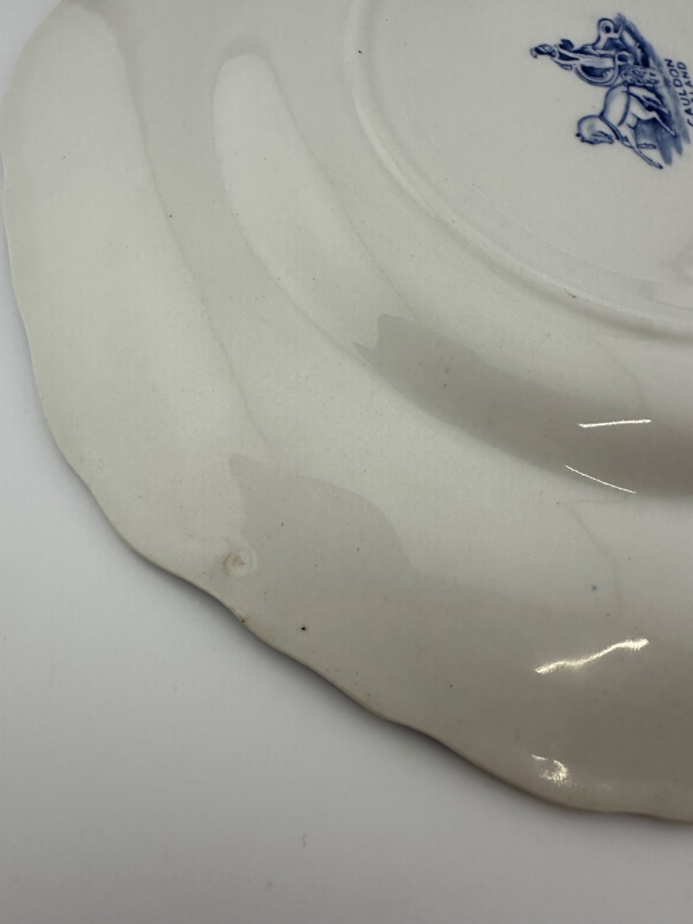 An octagonal-edged blue and white transferware plate featuring a central classical chariot scene surrounded by an ornate feather-patterned border. View VII