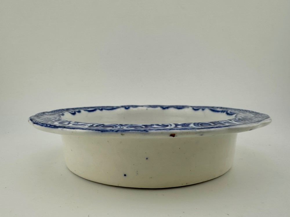 A circular blue and white transferware ceramic dish featuring a central printed depiction of abbey ruins framed by a decorative scrolled border. View III