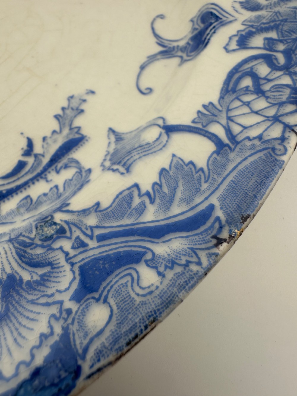 An early Victorian oval earthenware platter featuring a pale blue floral transferware border pattern and a gilded outer rim. View XI
