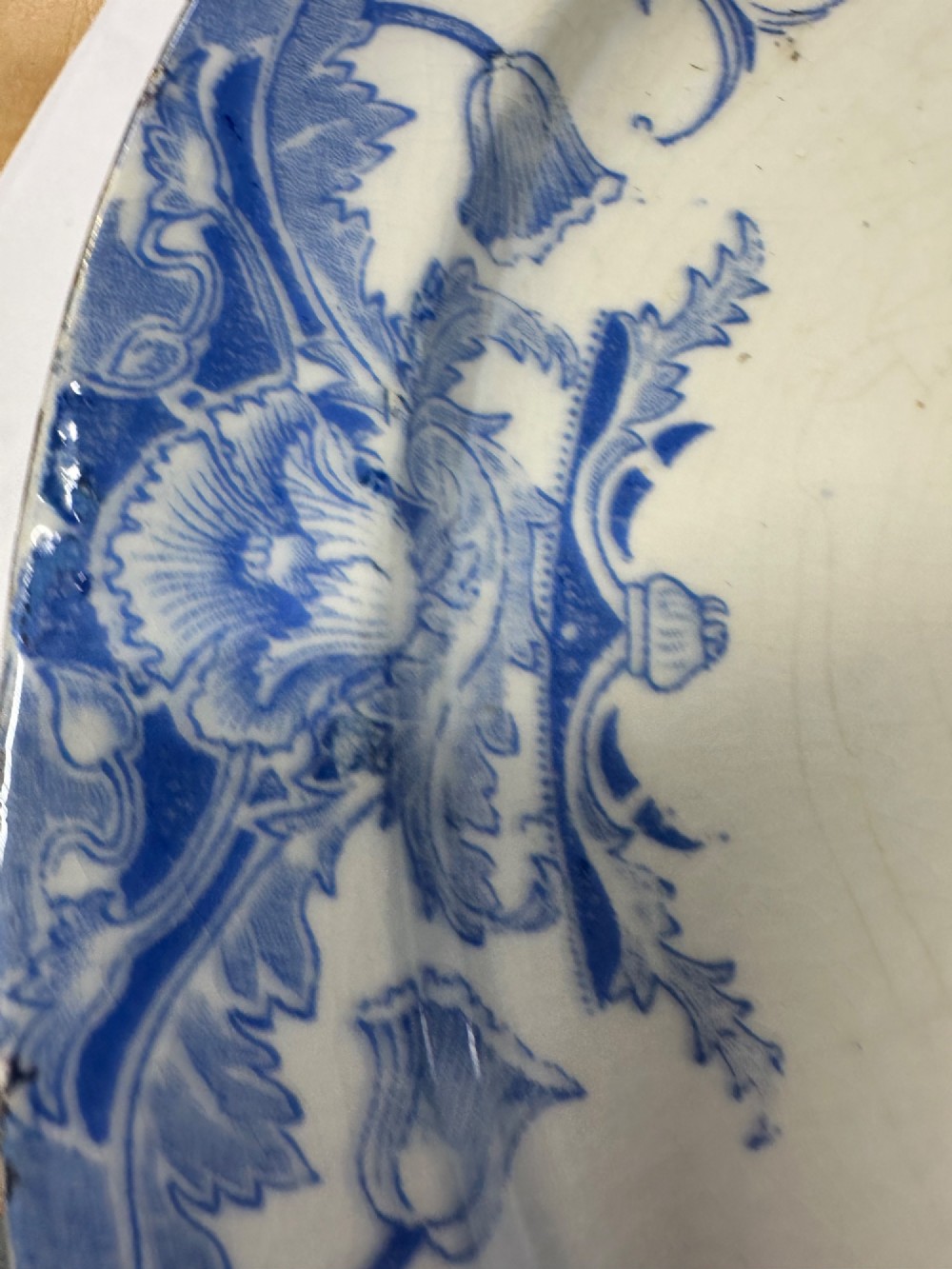 An early Victorian oval earthenware platter featuring a pale blue floral transferware border pattern and a gilded outer rim. View XIV