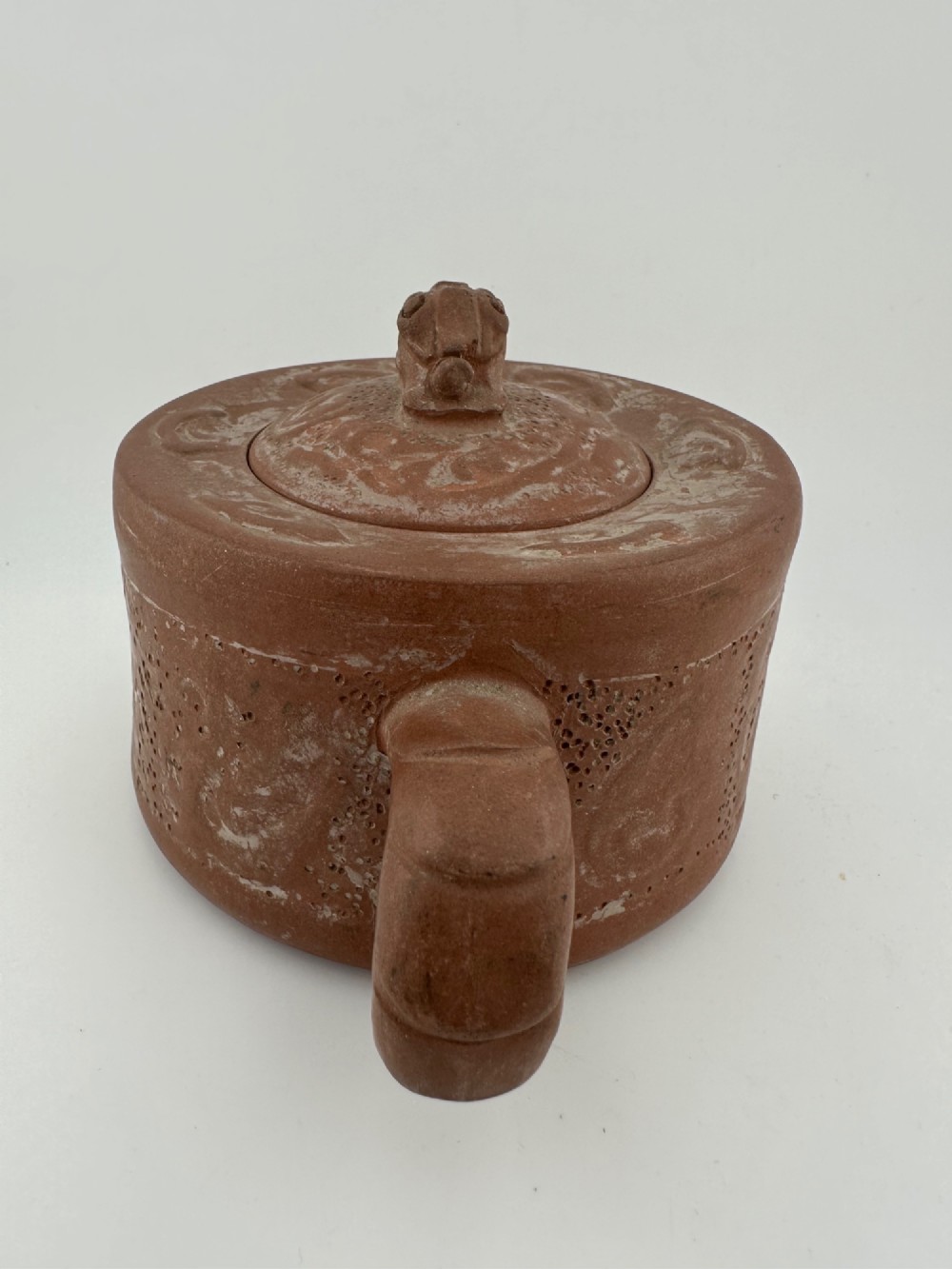 An antique brown Zisha clay teapot featuring archaistic relief decoration and a toad finial on the lid. View VI