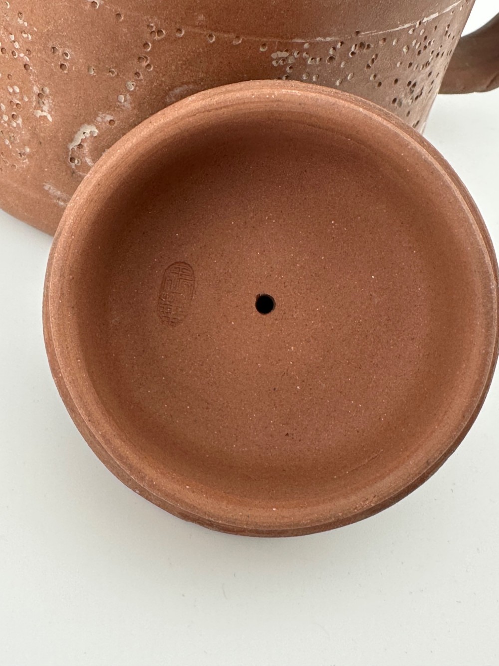 An antique brown Zisha clay teapot featuring archaistic relief decoration and a toad finial on the lid. View VII