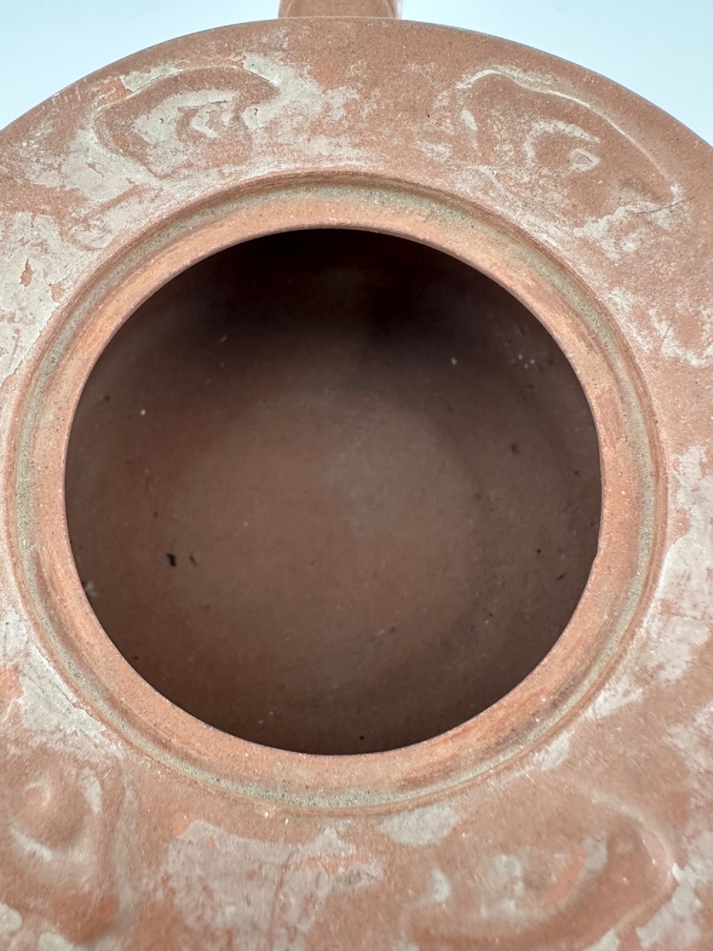 An antique brown Zisha clay teapot featuring archaistic relief decoration and a toad finial on the lid. View VIII