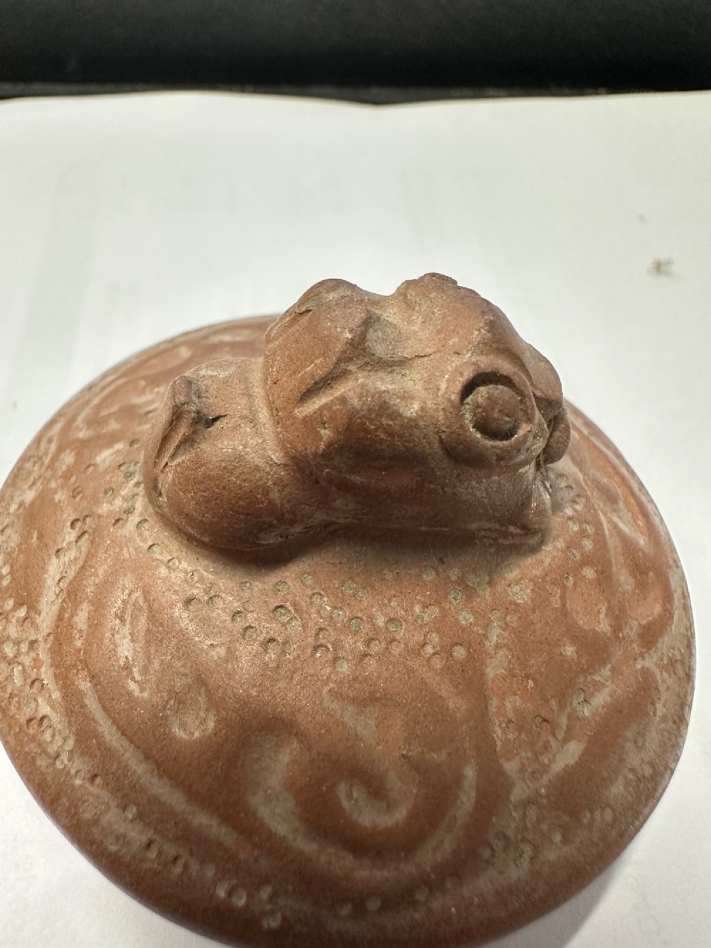 An antique brown Zisha clay teapot featuring archaistic relief decoration and a toad finial on the lid. View XI