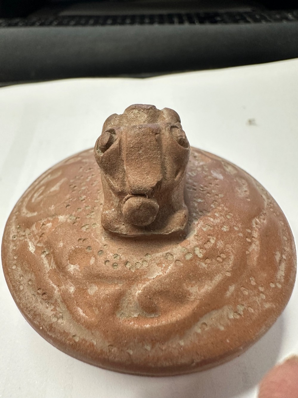 An antique brown Zisha clay teapot featuring archaistic relief decoration and a toad finial on the lid. View XII