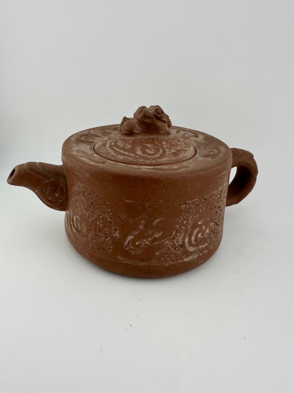 An antique brown Zisha clay teapot featuring archaistic relief decoration and a toad finial on the lid. View XIII