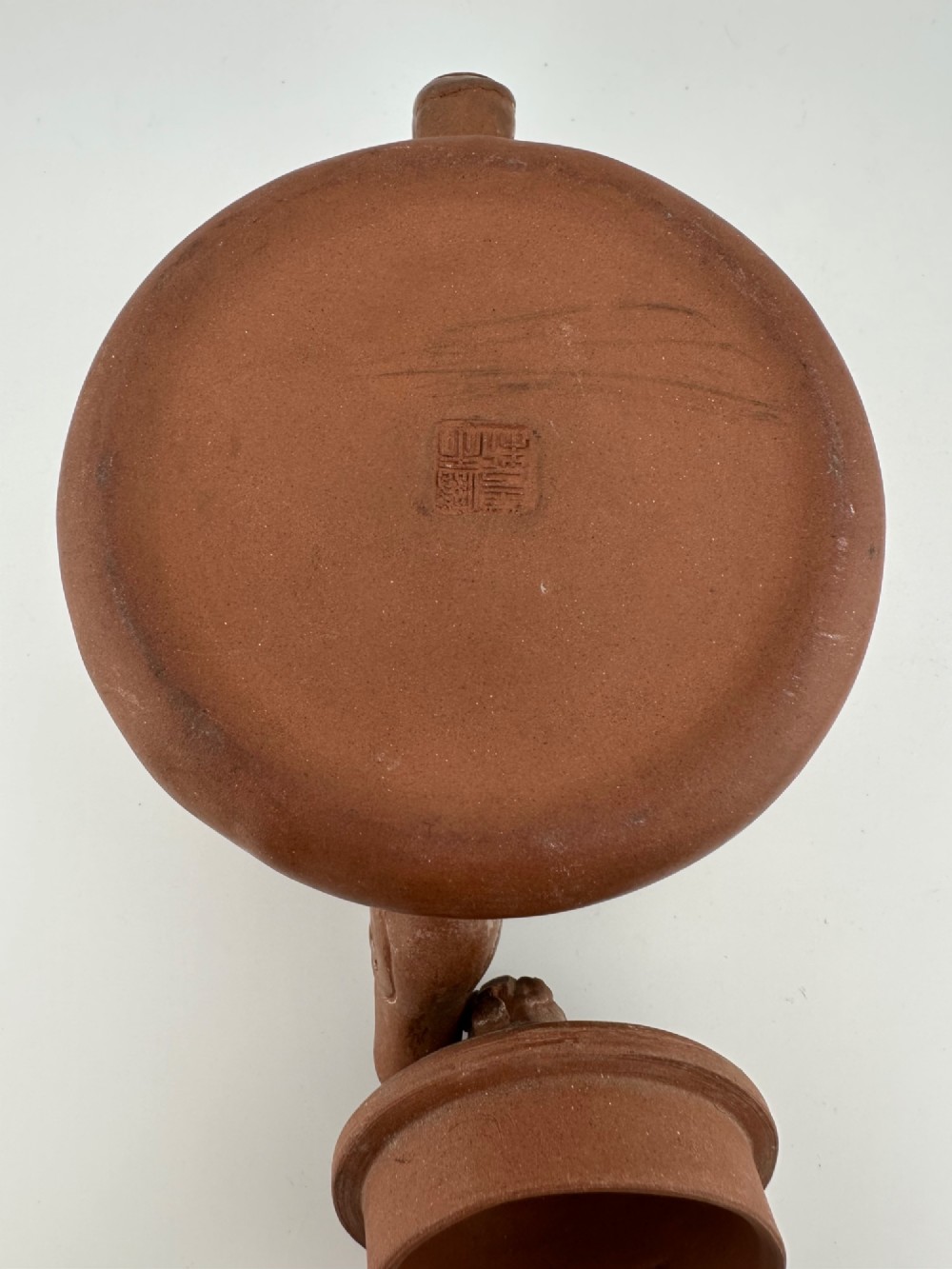 An antique brown Zisha clay teapot featuring archaistic relief decoration and a toad finial on the lid. View XV