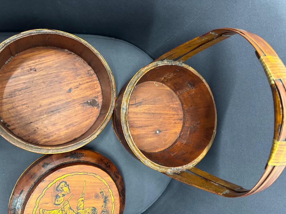 A three-tiered late 19th-century Chinese bamboo and wood food carrier with an arched handle, featuring hand-painted yellow flowers, birds, and goldfish against a warm brown lacquer finish. View IX