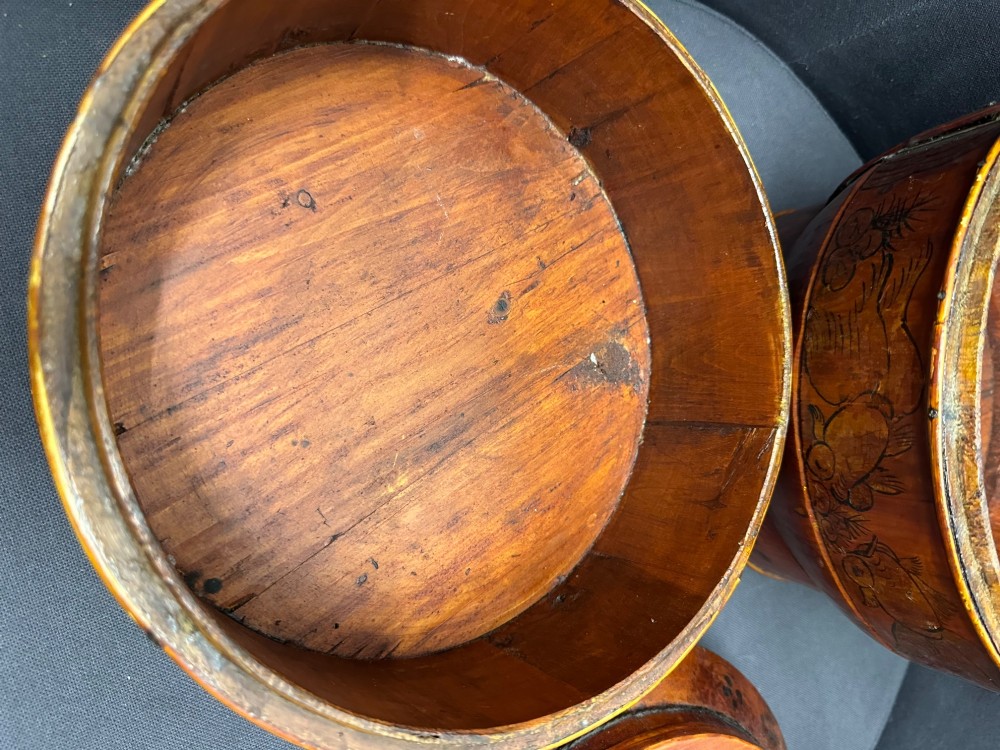 A three-tiered late 19th-century Chinese bamboo and wood food carrier with an arched handle, featuring hand-painted yellow flowers, birds, and goldfish against a warm brown lacquer finish. View XI