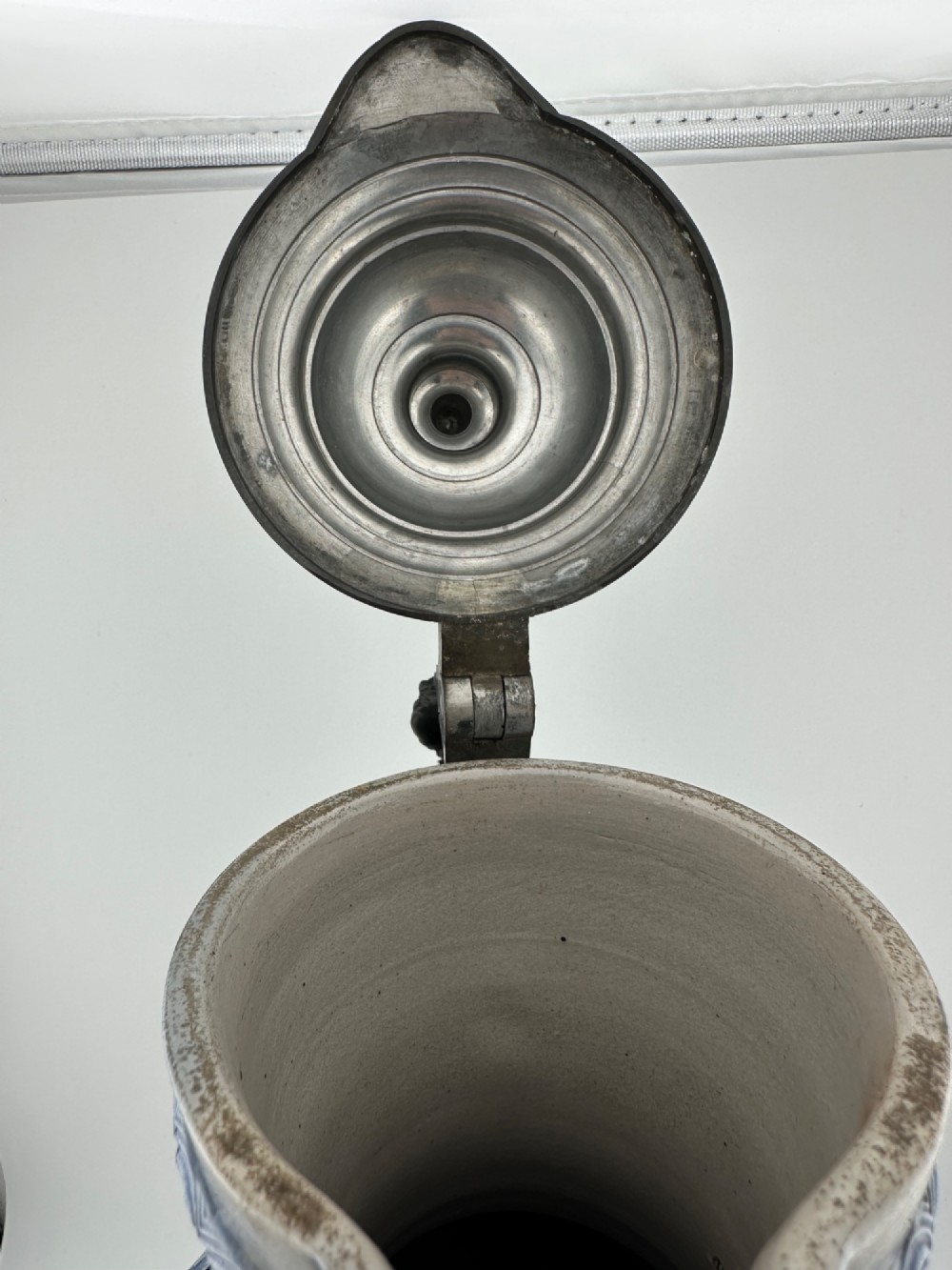 A blue and grey salt-glazed stoneware jug featuring relief-moulded geometric patterns, mask motifs, and a hinged pewter lid. View XI