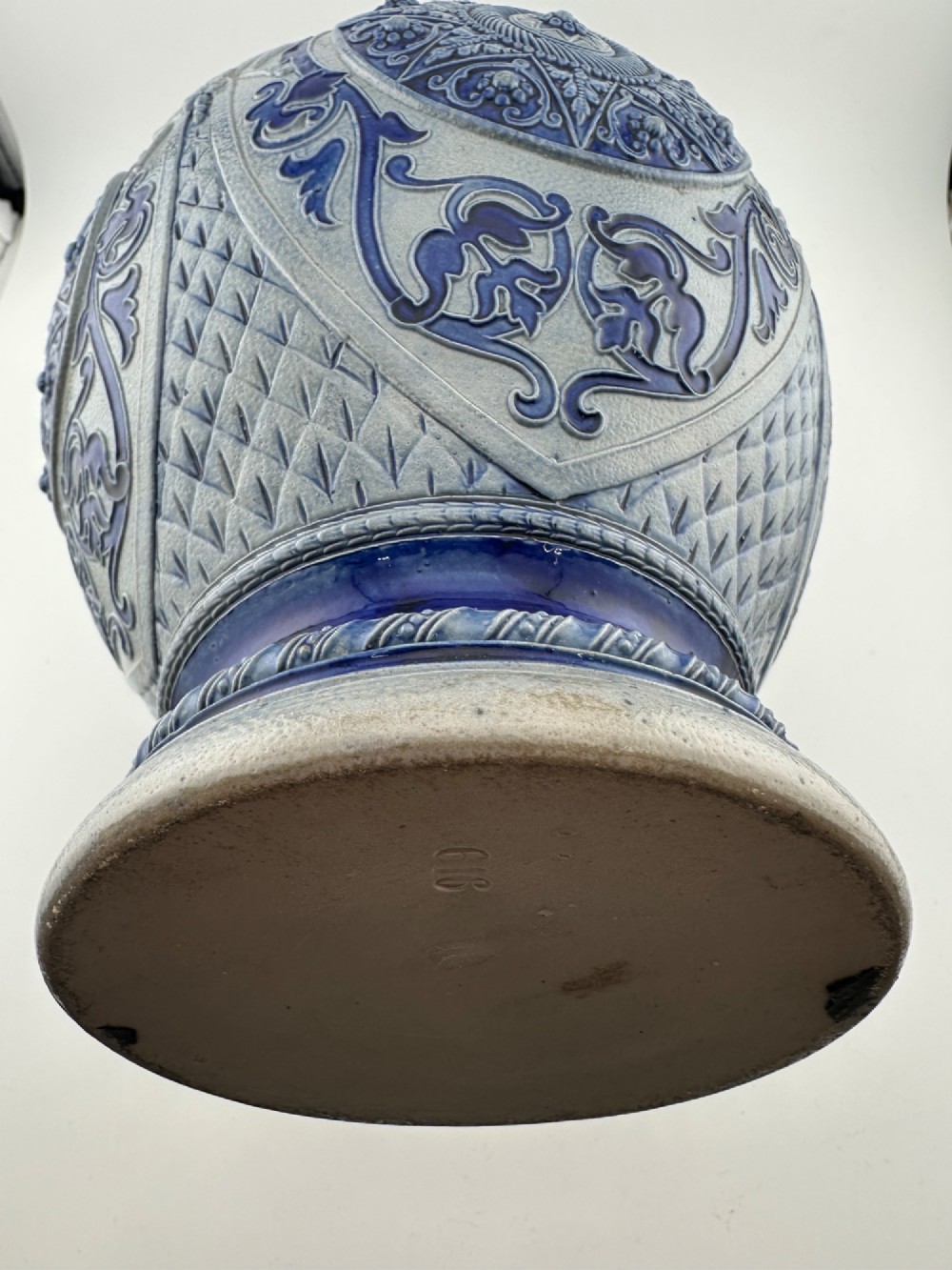 A blue and grey salt-glazed stoneware jug featuring relief-moulded geometric patterns, mask motifs, and a hinged pewter lid. View XIV