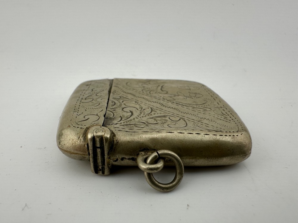 An antique rectangular silver-plated vesta case featuring hand-engraved scrollwork, an open hinged lid, and a side suspension ring. View VIII