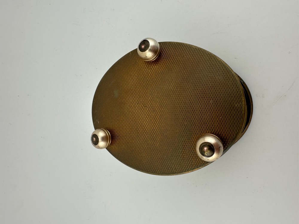 An oval vintage metal trinket box featuring a printed floral motif on the lid, star-patterned side panels, small rounded feet, and a velvet lining. View IX