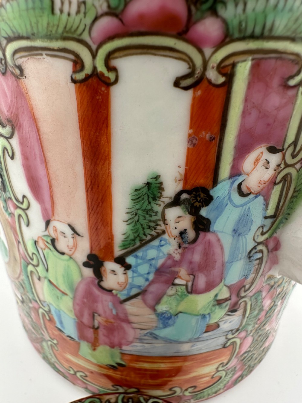 A Chinese Famille Rose cylindrical ceramic teapot with hand-painted court figures set beside its fitted woven wicker carrying case. View XIV