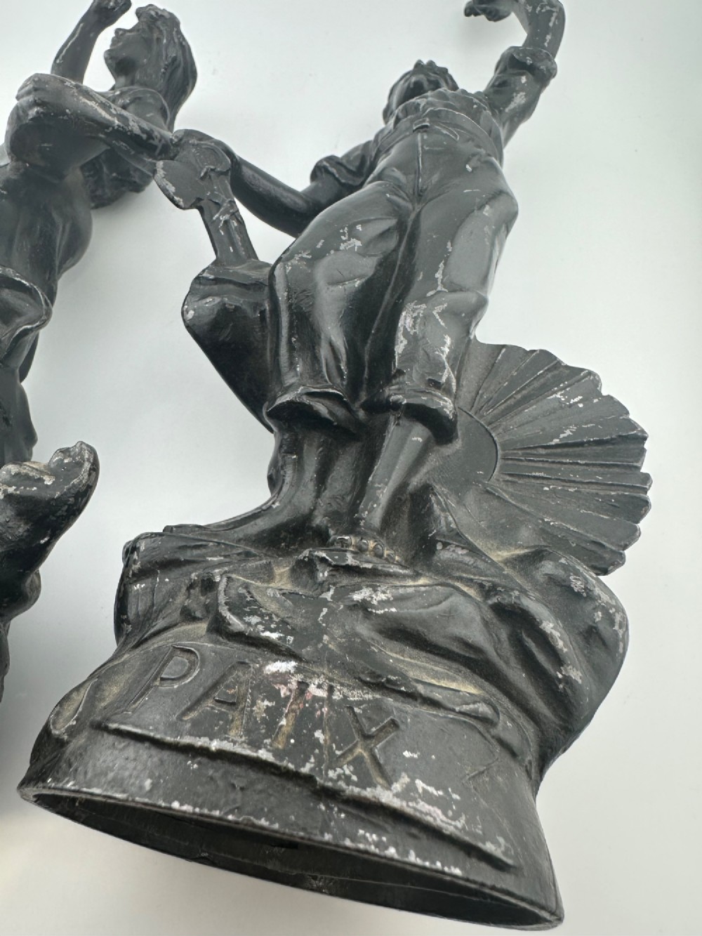 A pair of dark bronze-finished French spelter allegorical figures raised on moulded circular bases representing Mutualite and Paix. View XII