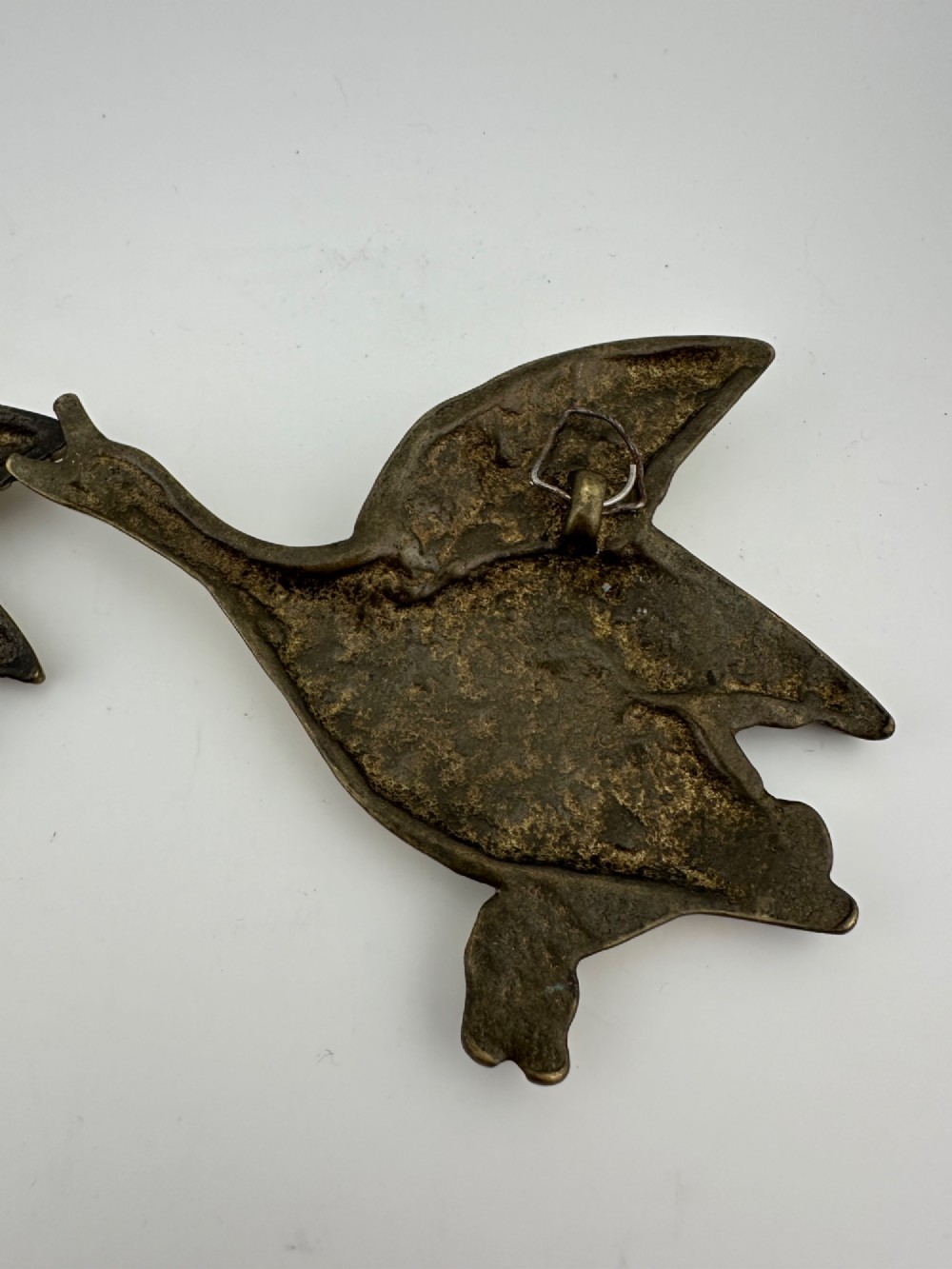 A set of three graduated cast brass flying geese wall plaques arranged by size with textured feather detailing. View VII