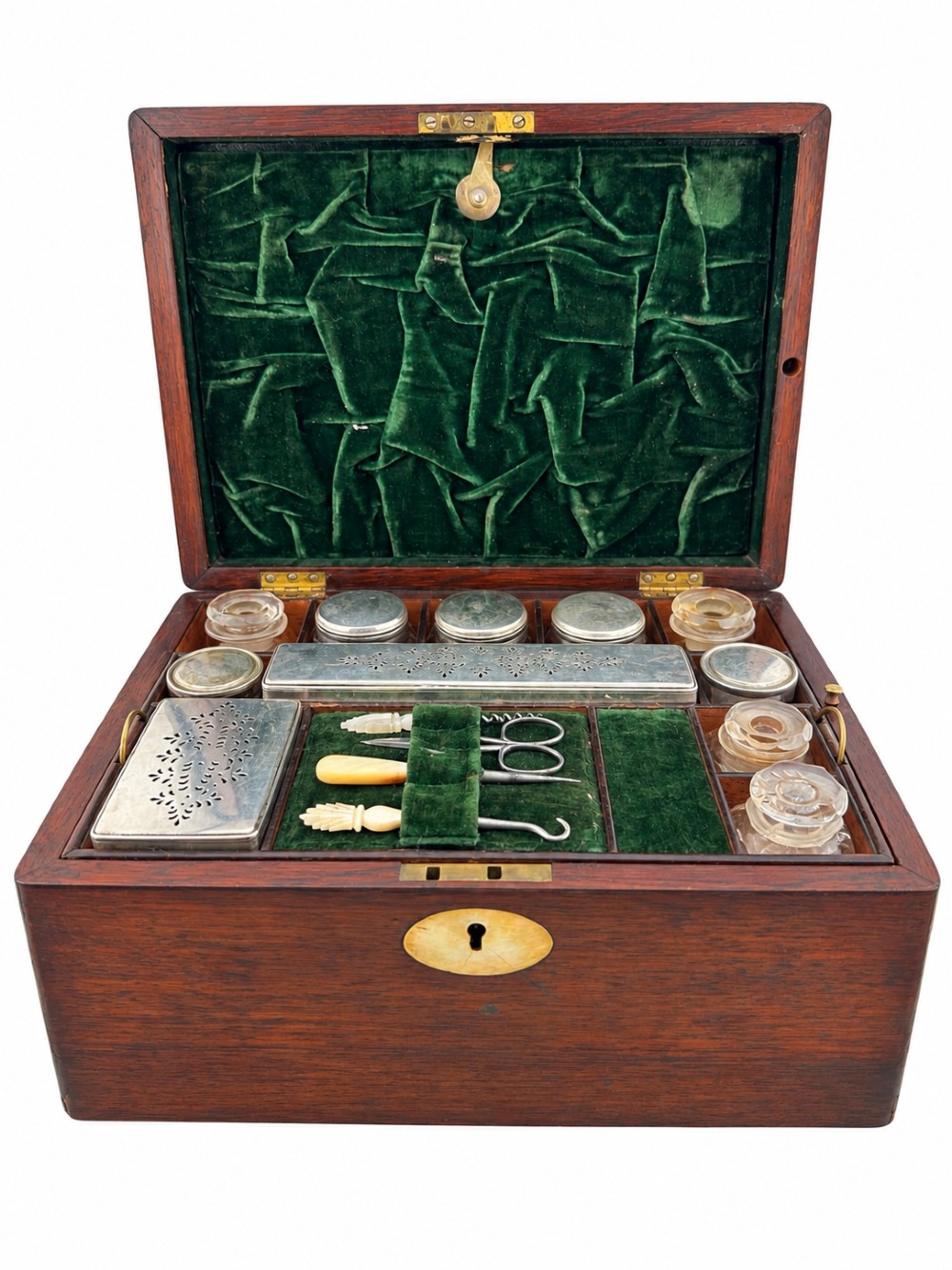 An open Victorian rosewood vanity box featuring a ruched green velvet lid lining, fitted interior compartments with silver-capped glass bottles, and a mother-of-pearl escutcheon.