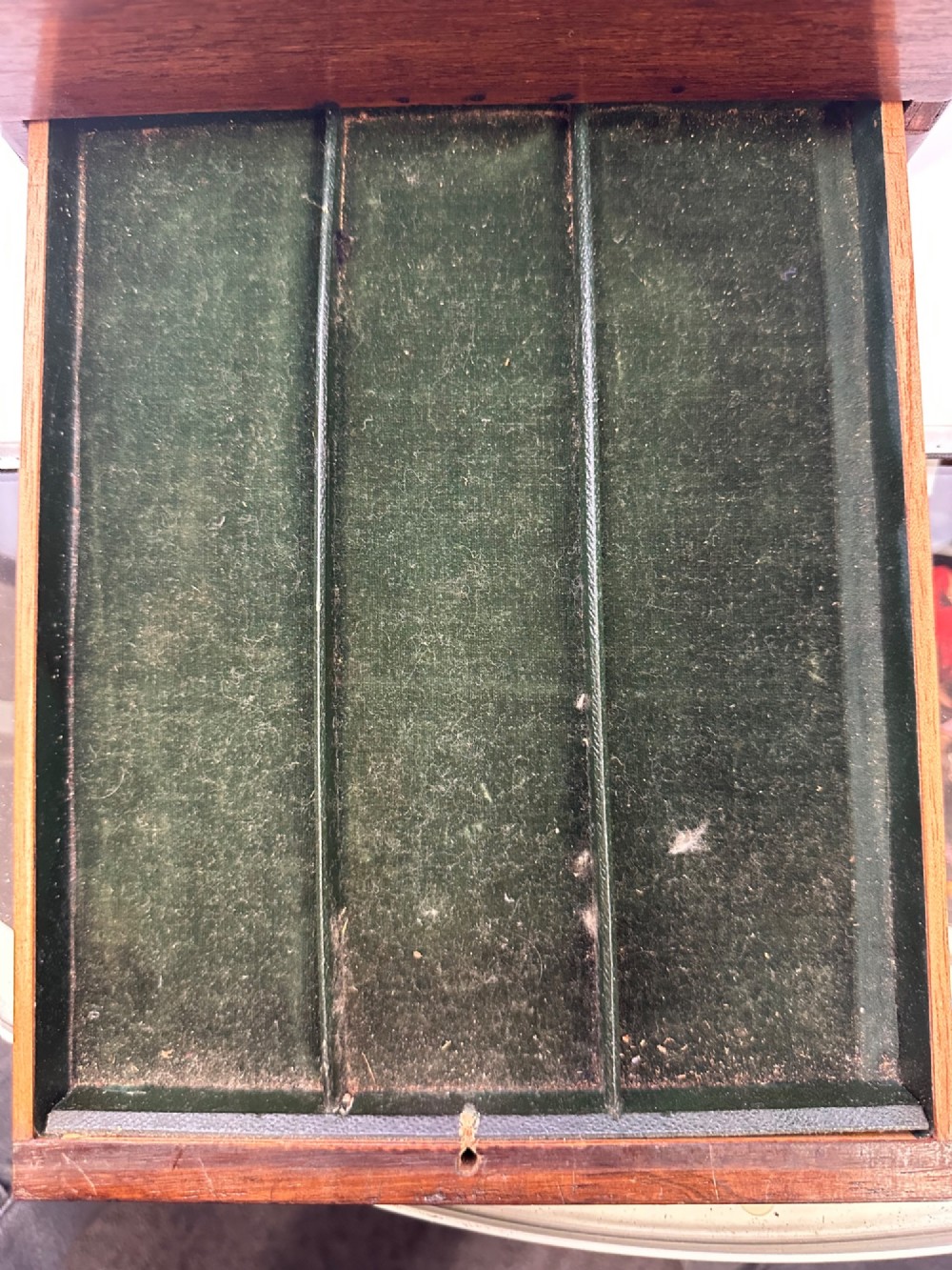 An open Victorian rosewood vanity box featuring a ruched green velvet lid lining, fitted interior compartments with silver-capped glass bottles, and a mother-of-pearl escutcheon. View IV