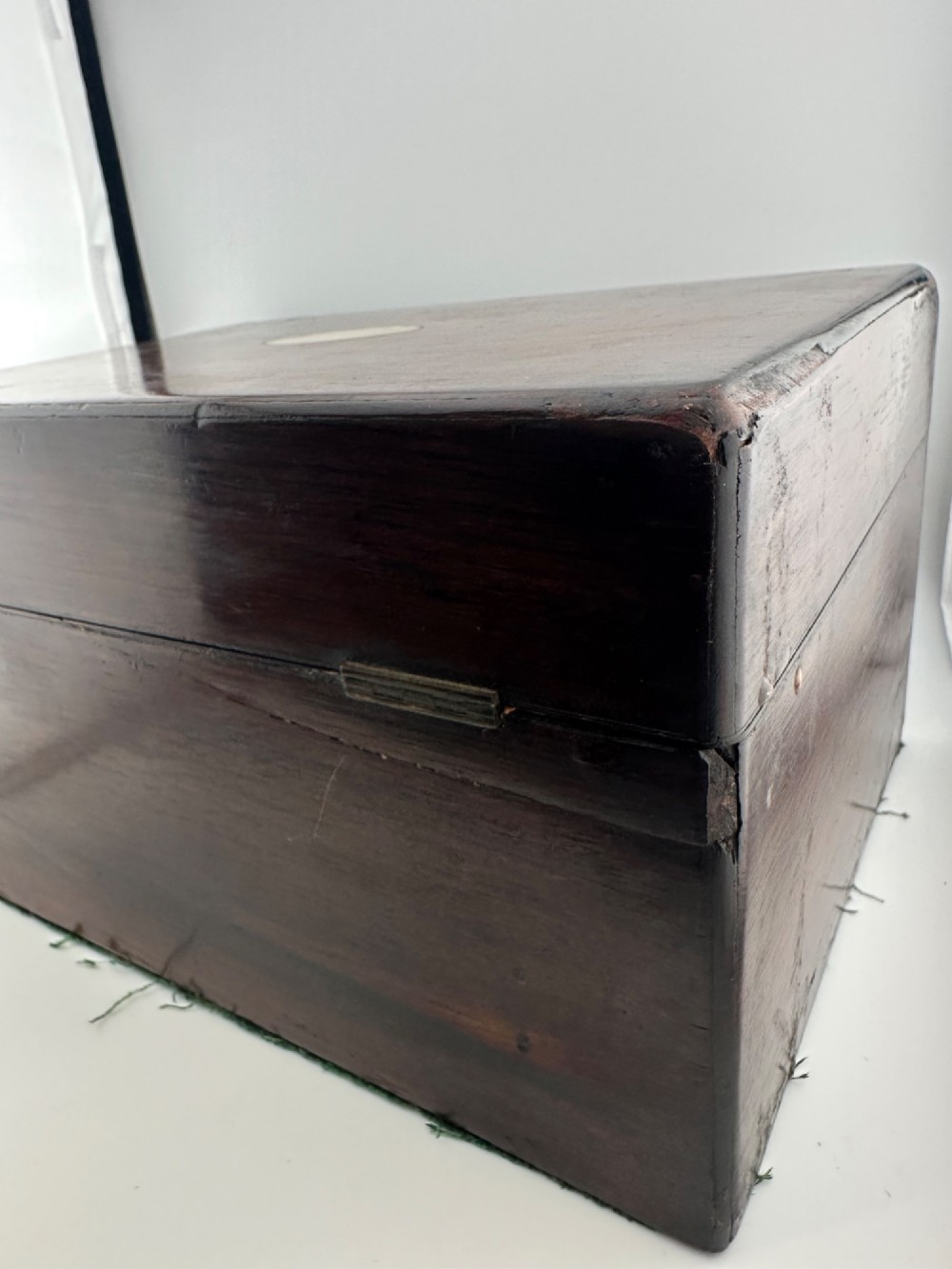An open Victorian rosewood vanity box featuring a ruched green velvet lid lining, fitted interior compartments with silver-capped glass bottles, and a mother-of-pearl escutcheon. View VIII