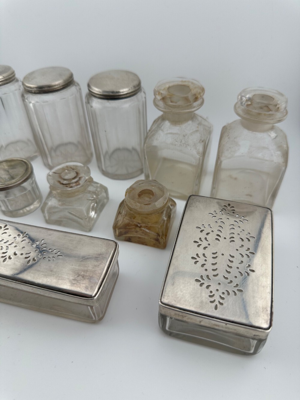 An open Victorian rosewood vanity box featuring a ruched green velvet lid lining, fitted interior compartments with silver-capped glass bottles, and a mother-of-pearl escutcheon. View XI