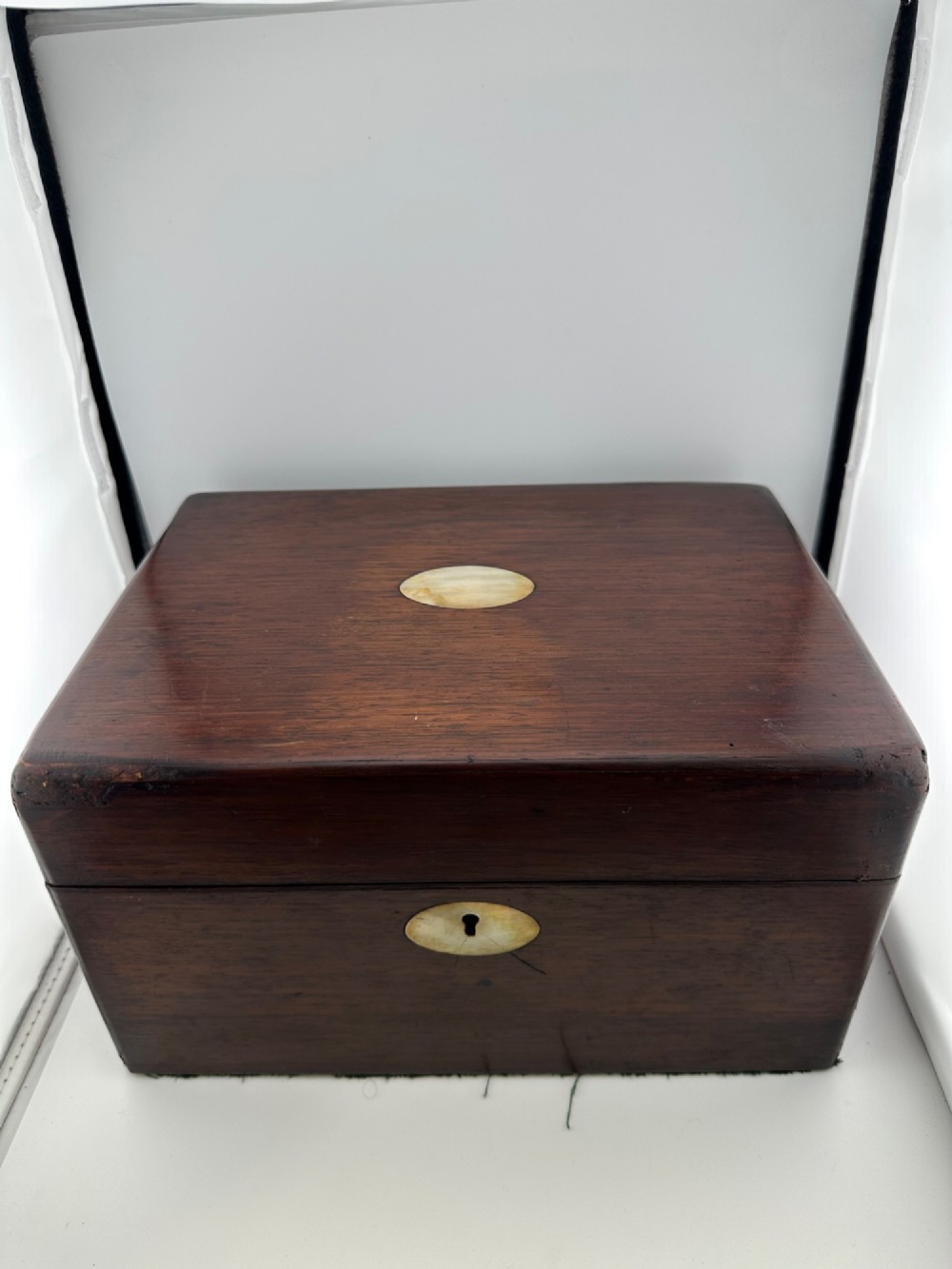 An open Victorian rosewood vanity box featuring a ruched green velvet lid lining, fitted interior compartments with silver-capped glass bottles, and a mother-of-pearl escutcheon. View XIII