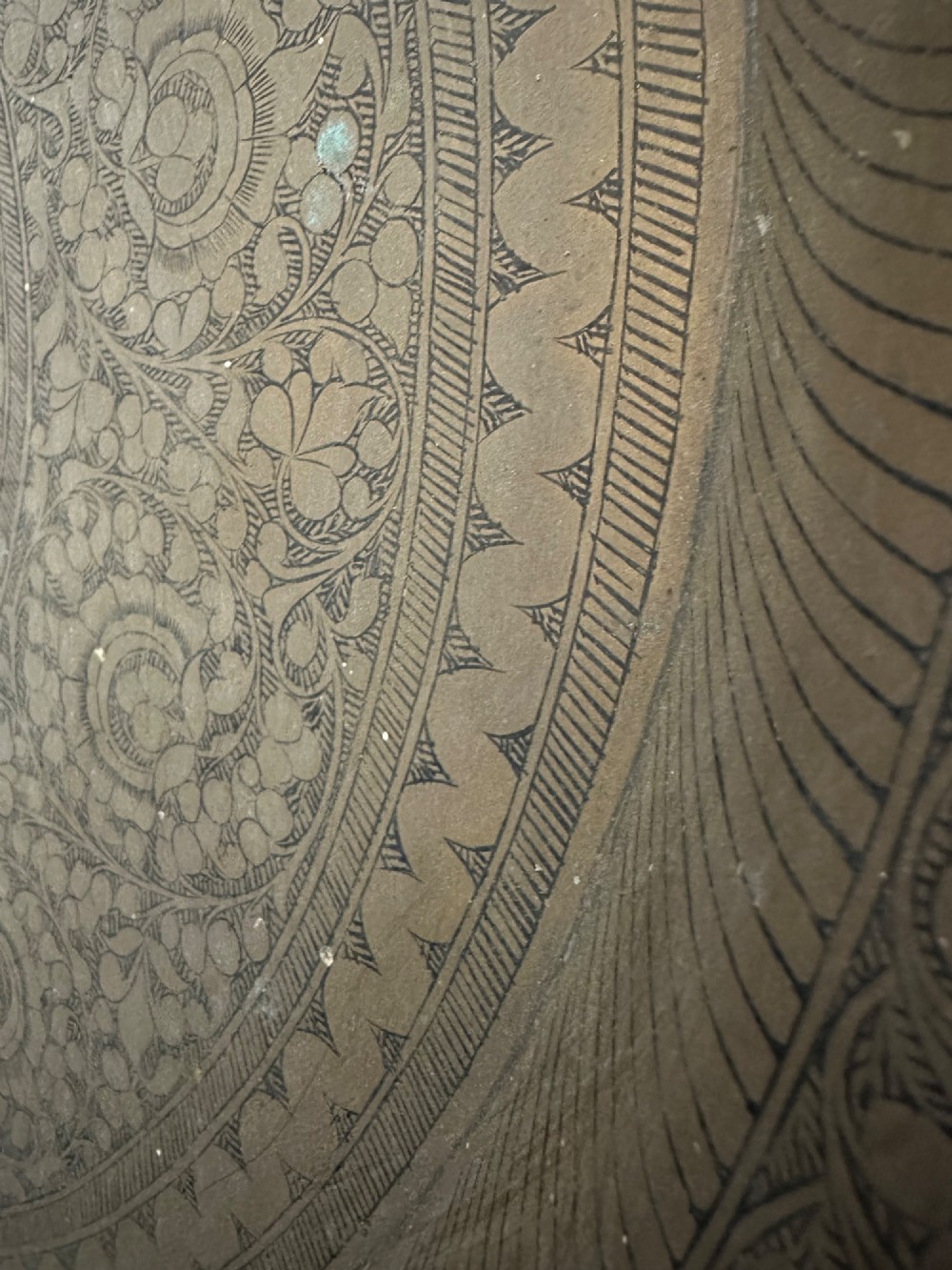 A large circular brass tray featuring intricate hand-engraved concentric floral and geometric patterns with a shallow rolled rim. View XI