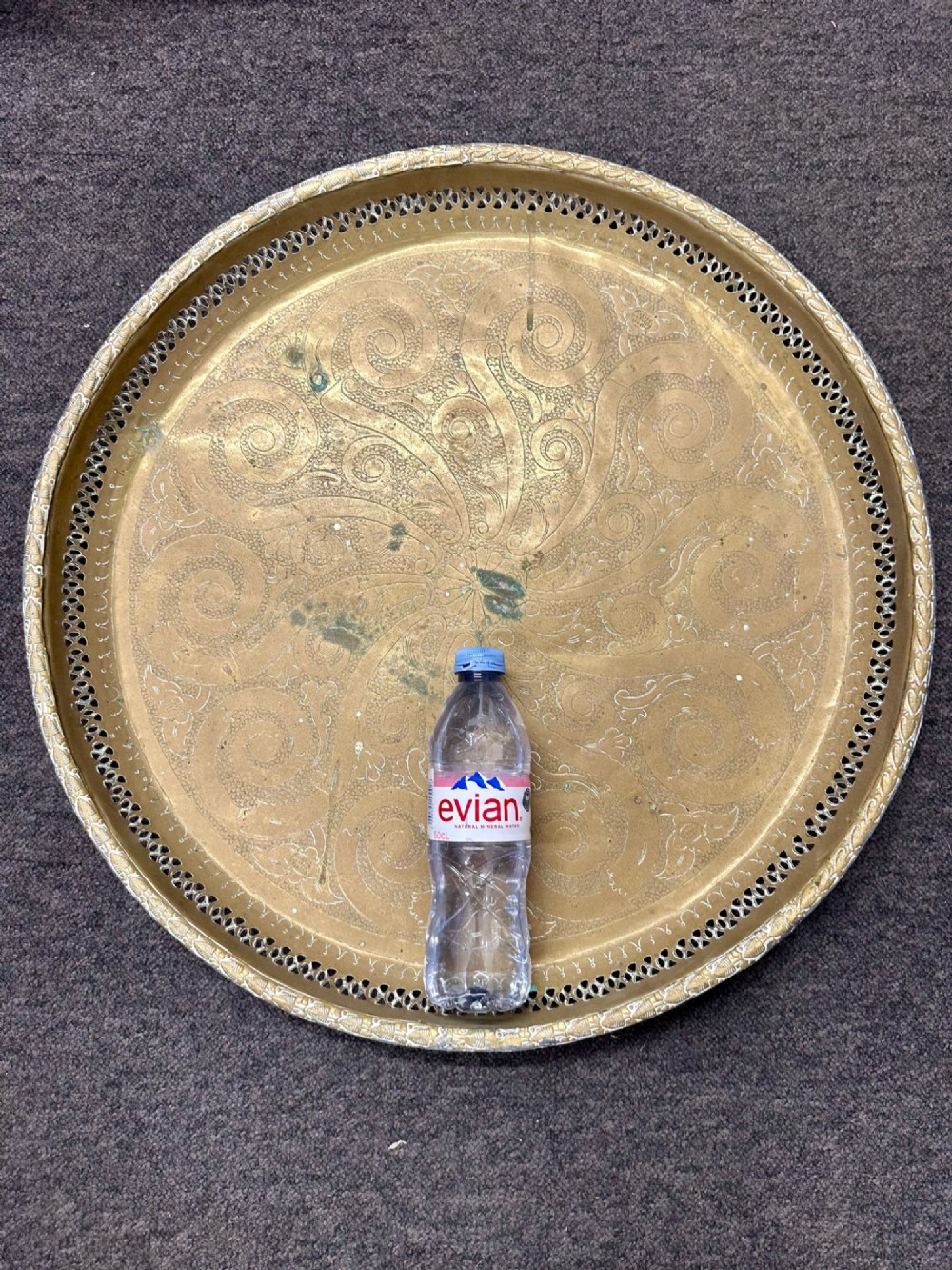 A circular antique brass tray featuring an intricately engraved swirling floral pattern and a pierced gallery rim. View III