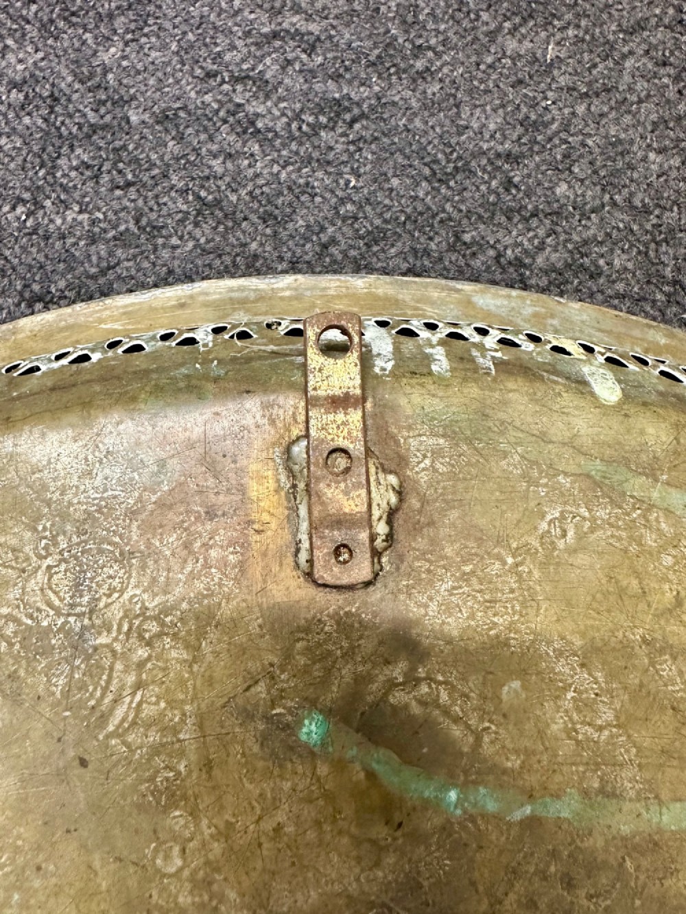 A circular antique brass tray featuring an intricately engraved swirling floral pattern and a pierced gallery rim. View V