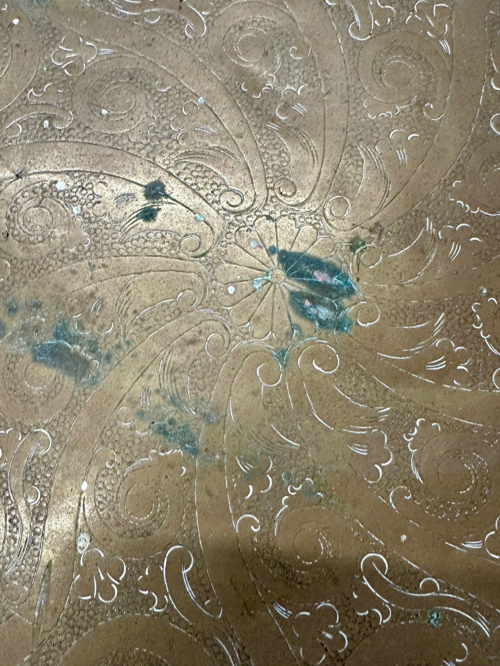 A circular antique brass tray featuring an intricately engraved swirling floral pattern and a pierced gallery rim. View VIII