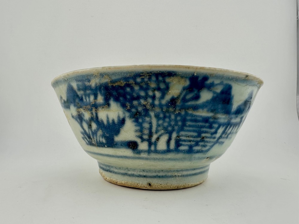 A nineteenth century Chinese Qing Dynasty shipwreck porcelain bowl decorated with cobalt blue underglaze landscape imagery.