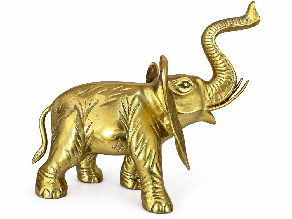 A solid brass sculpture of an elephant standing with its trunk raised up. View II