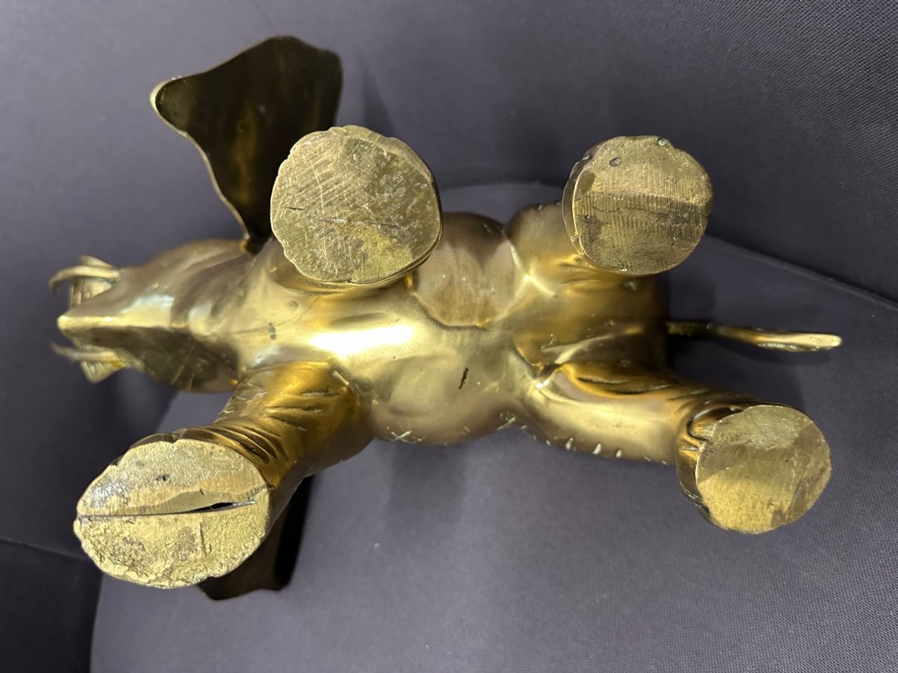 A solid brass sculpture of an elephant standing with its trunk raised up. View V