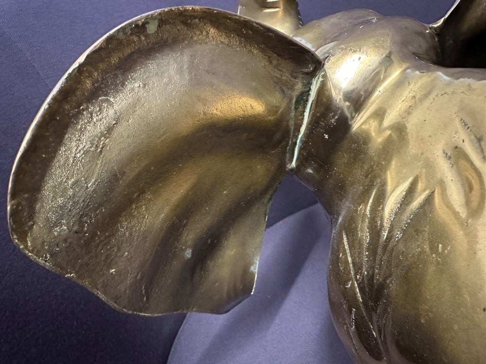 A solid brass sculpture of an elephant standing with its trunk raised up. View VII