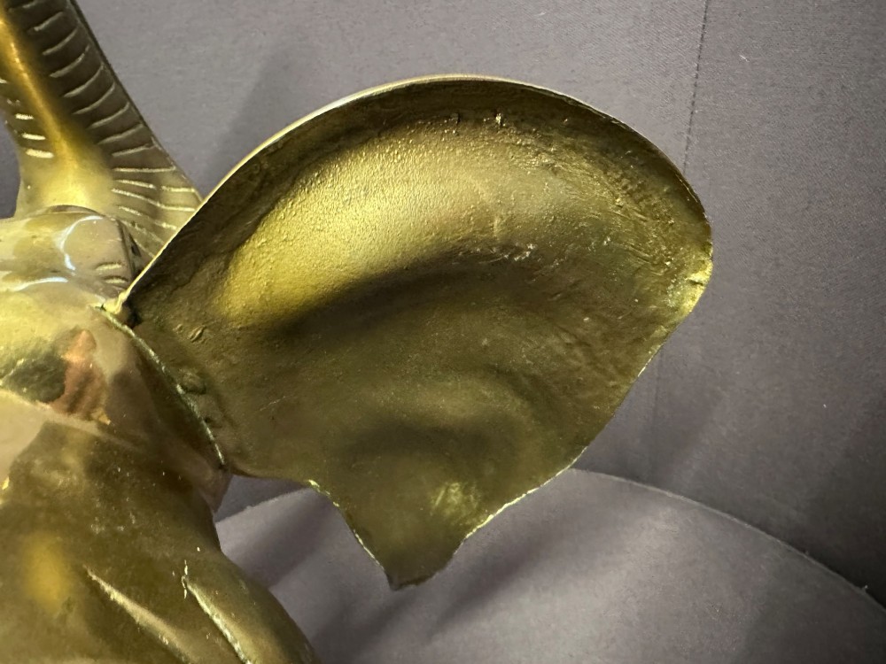 A solid brass sculpture of an elephant standing with its trunk raised up. View VIII