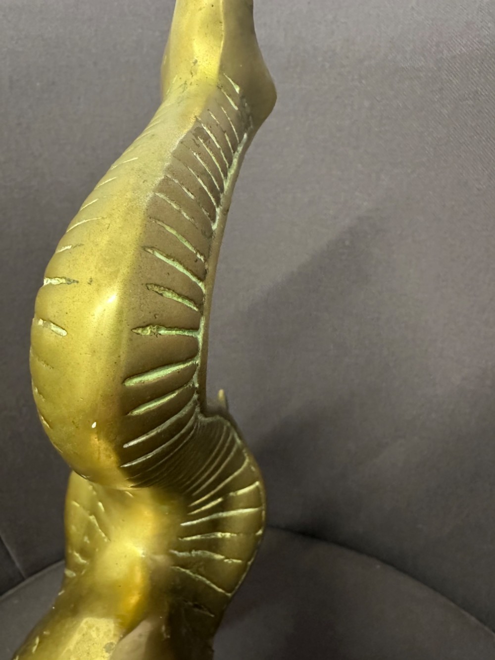 A solid brass sculpture of an elephant standing with its trunk raised up. View IX