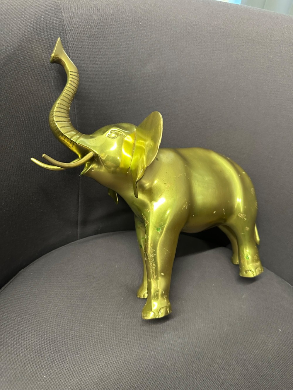 A vintage cast brass elephant sculpture standing with its trunk raised high. View IV