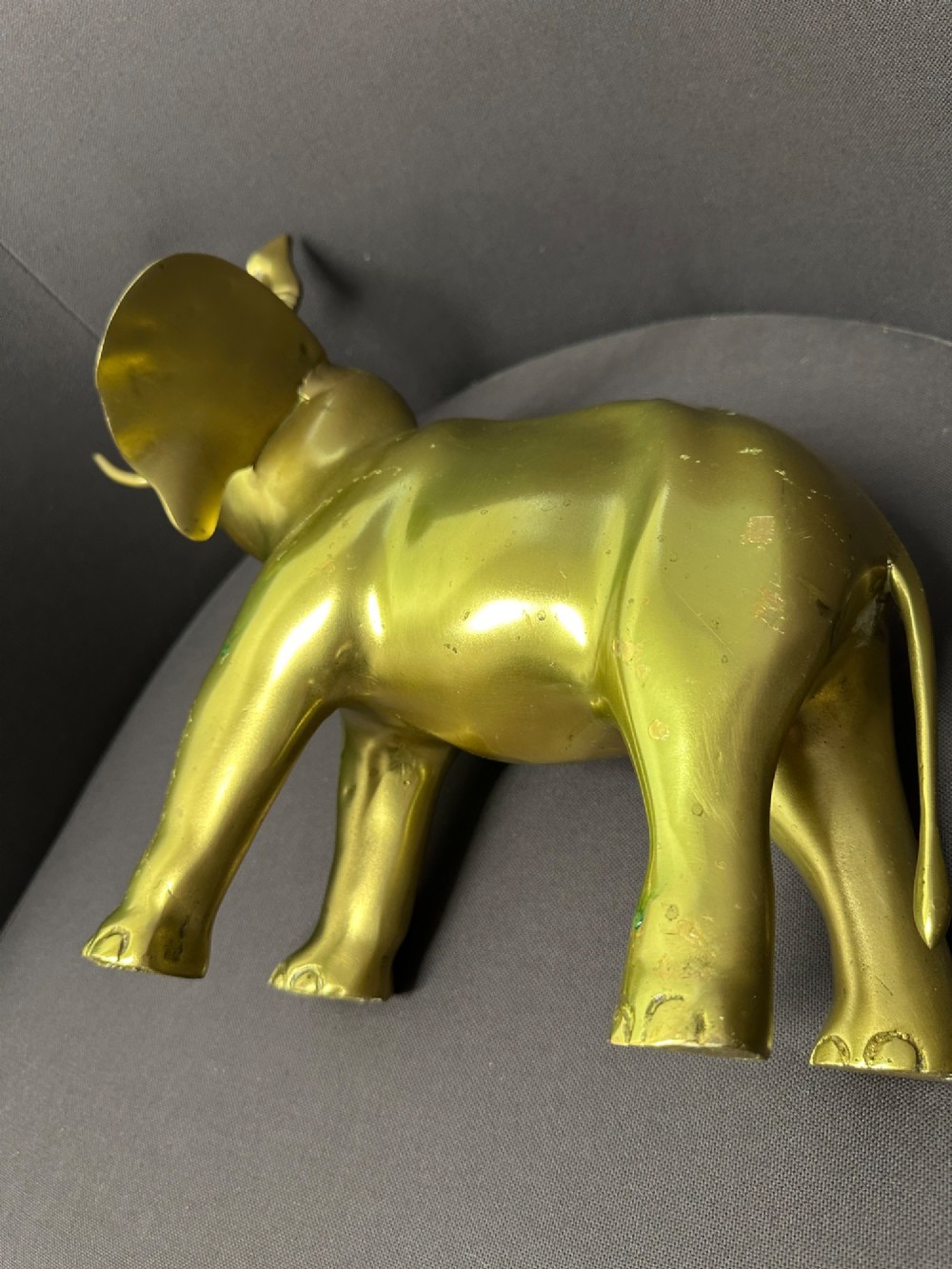 A vintage cast brass elephant sculpture standing with its trunk raised high. View V