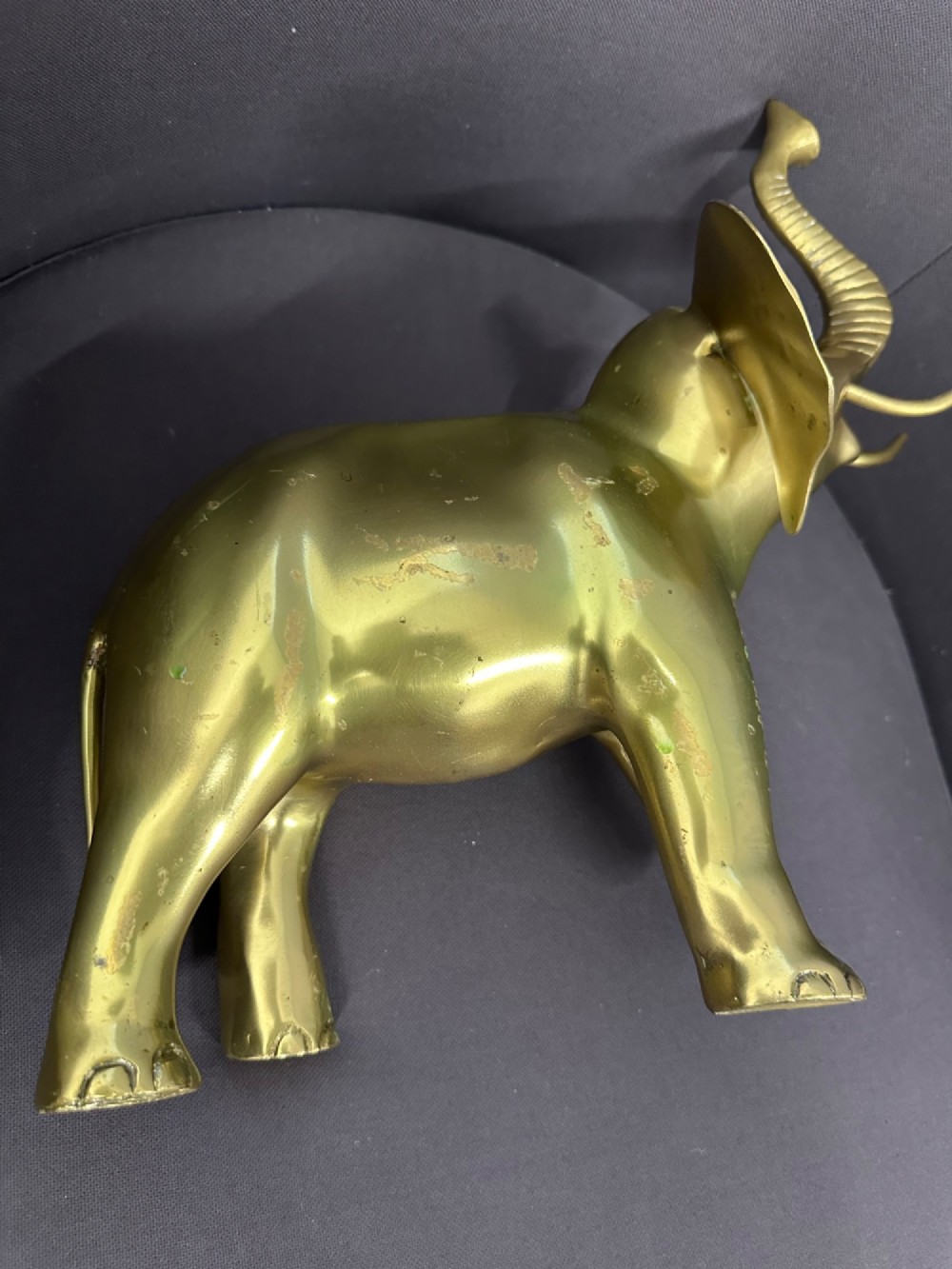 A vintage cast brass elephant sculpture standing with its trunk raised high. View VIII