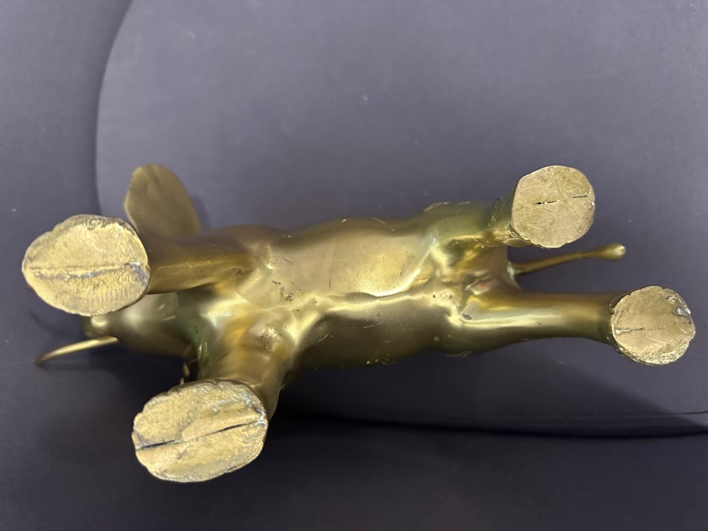 A vintage cast brass elephant sculpture standing with its trunk raised high. View X
