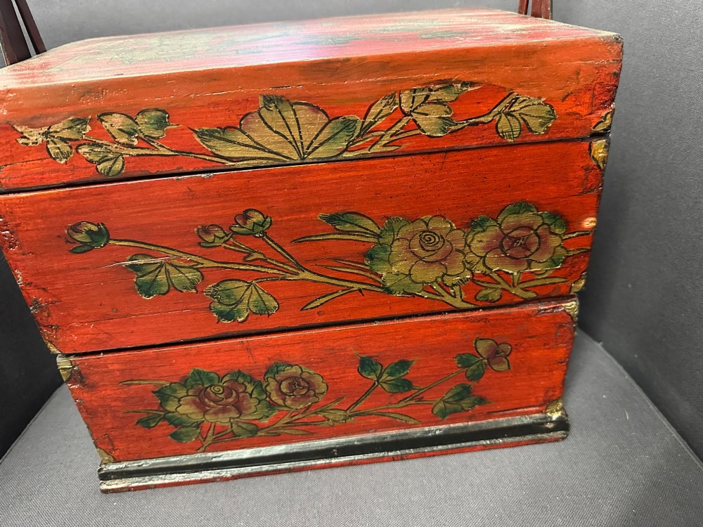 A three-tiered Chinese red lacquer wedding basket featuring hand-painted gold floral motifs and a black wooden carrying handle. View XII