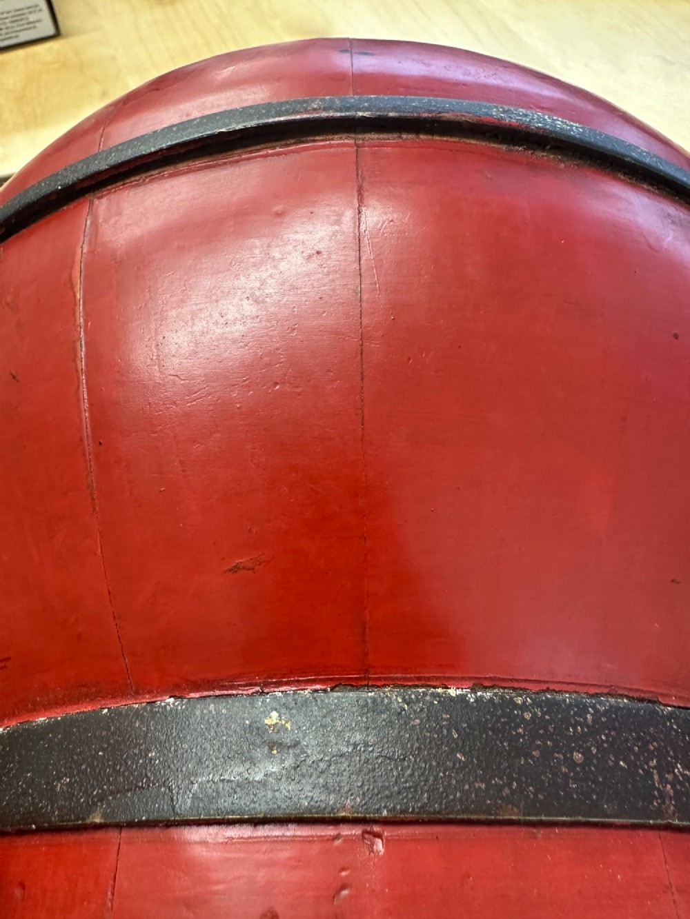 A traditional Chinese red and black lacquered rice basket featuring a high arched handle and painted decorative motifs on the lid. View IX