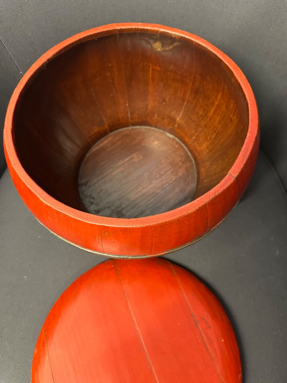 A traditional Chinese red and black lacquered rice basket featuring a high arched handle and painted decorative motifs on the lid. View XIII