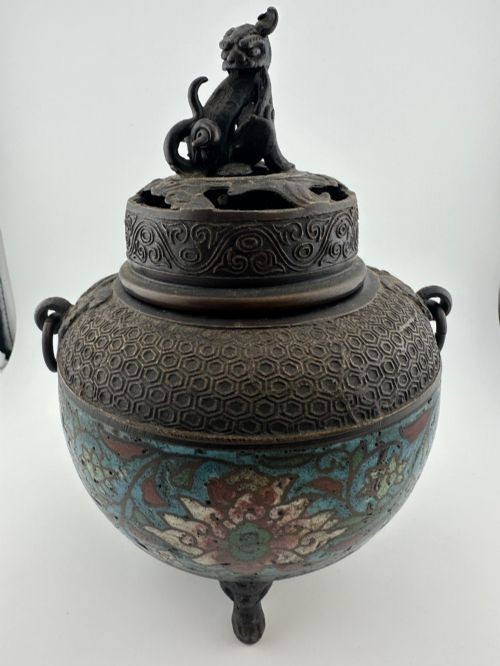 A dark bronze globular tripod incense burner featuring colourful enamel lotus motifs, side ring handles, and a pierced lid with a seated Qilin finial. View II