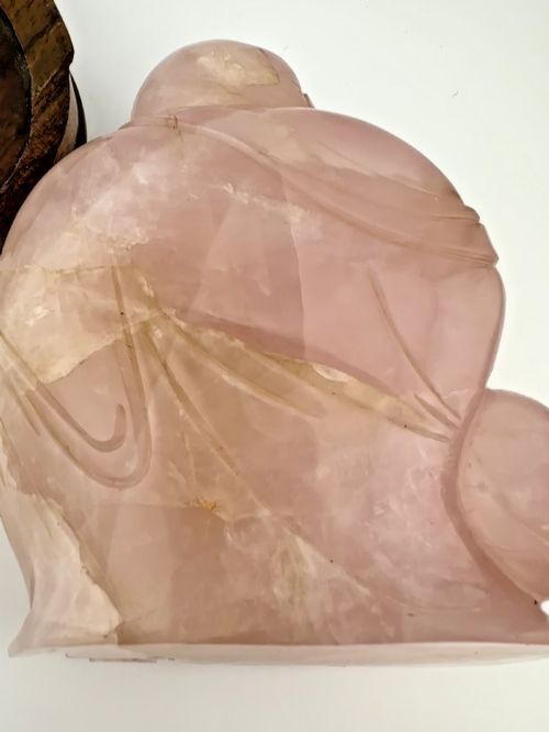 A carved pale pink rose quartz figure of a seated Laughing Buddha set upon a fitted carved dark hardwood base. View VIII