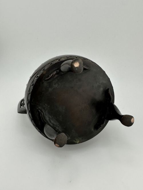 A dark patinated bronze tripod censer with a lid surmounted by a Qilin finial and featuring two tall pierced handles. View VIII
